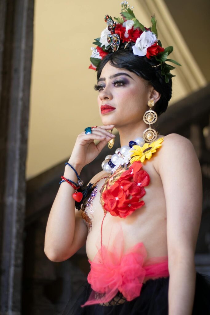 Woman posing with creative floral headpiece and fashion elements indoors.